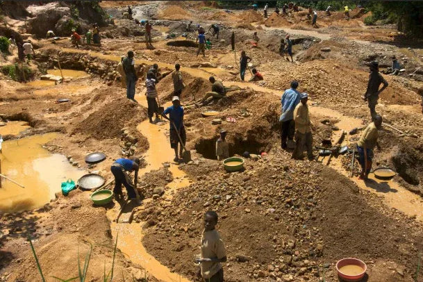 Miners at work in a pit, sifting soil for minerals and crystals, using pans and tools in muddy terrain
