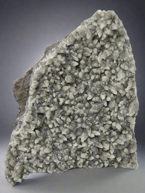 Quartz crystal cluster from Brazil, natural mineral specimen with sharp points and gray matrix