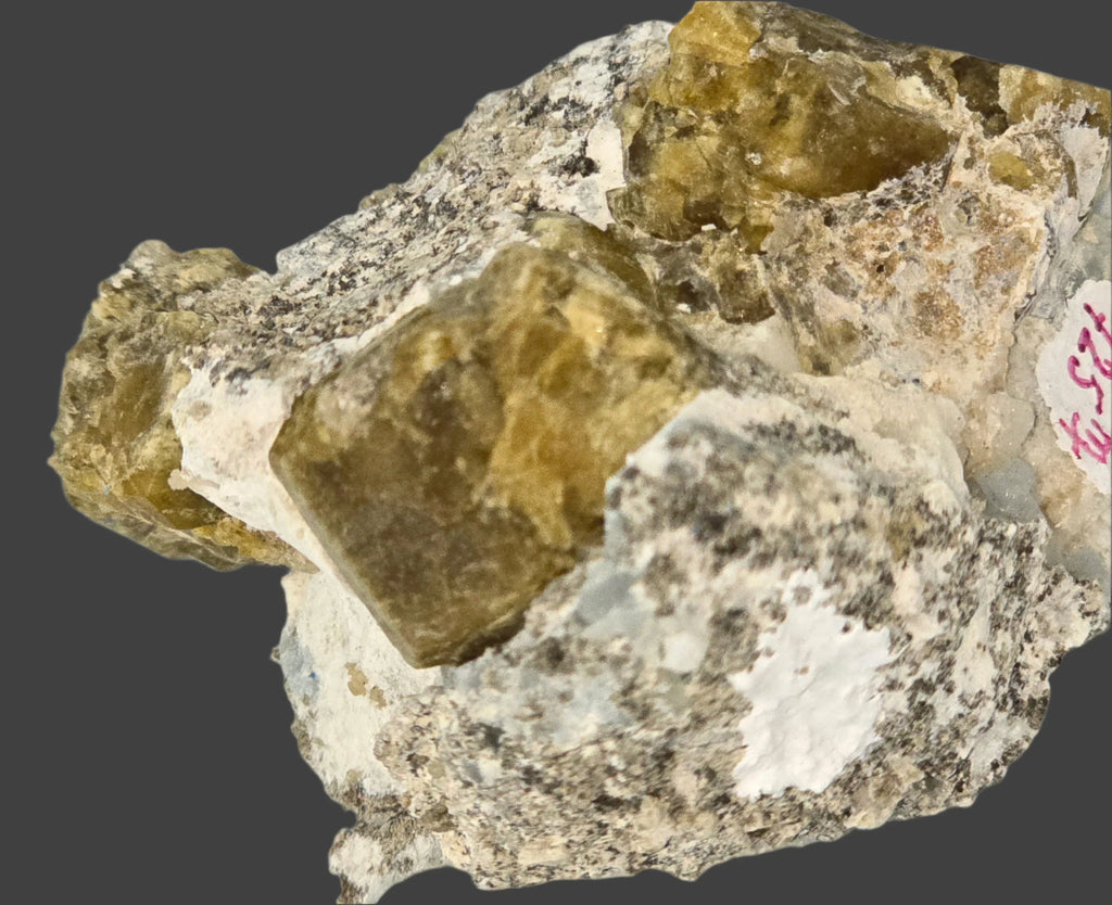 Fluorite crystal specimen on matrix, showcasing yellow-green cubic crystals with white mineral base