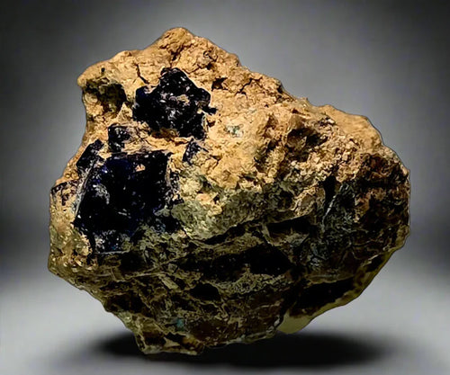 Cassiterite on matrix from Bolivia, dark crystals on golden host rock