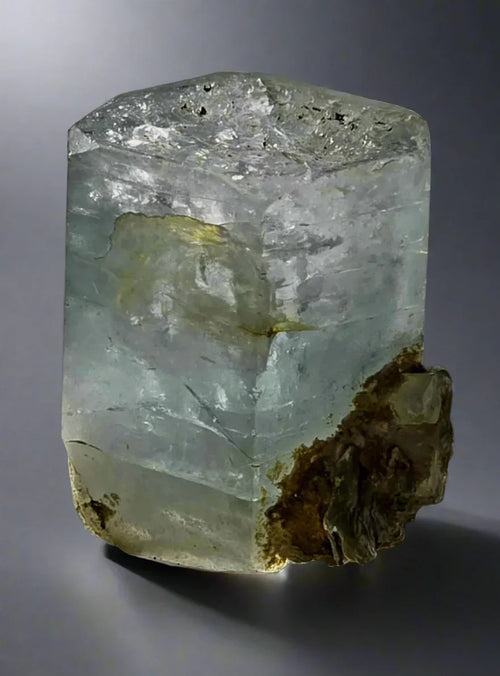 Fluorite crystal specimen with greenish-blue hue and matrix, showcasing natural mineral formation
