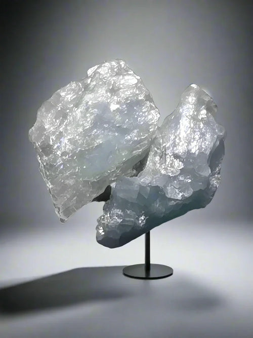 Celestine mineral specimen from Madagascar, translucent blue-white crystals on display stand