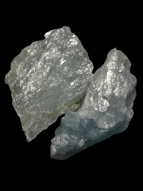 Celestine mineral specimen with iridescent sheen, raw crystal formation against black background