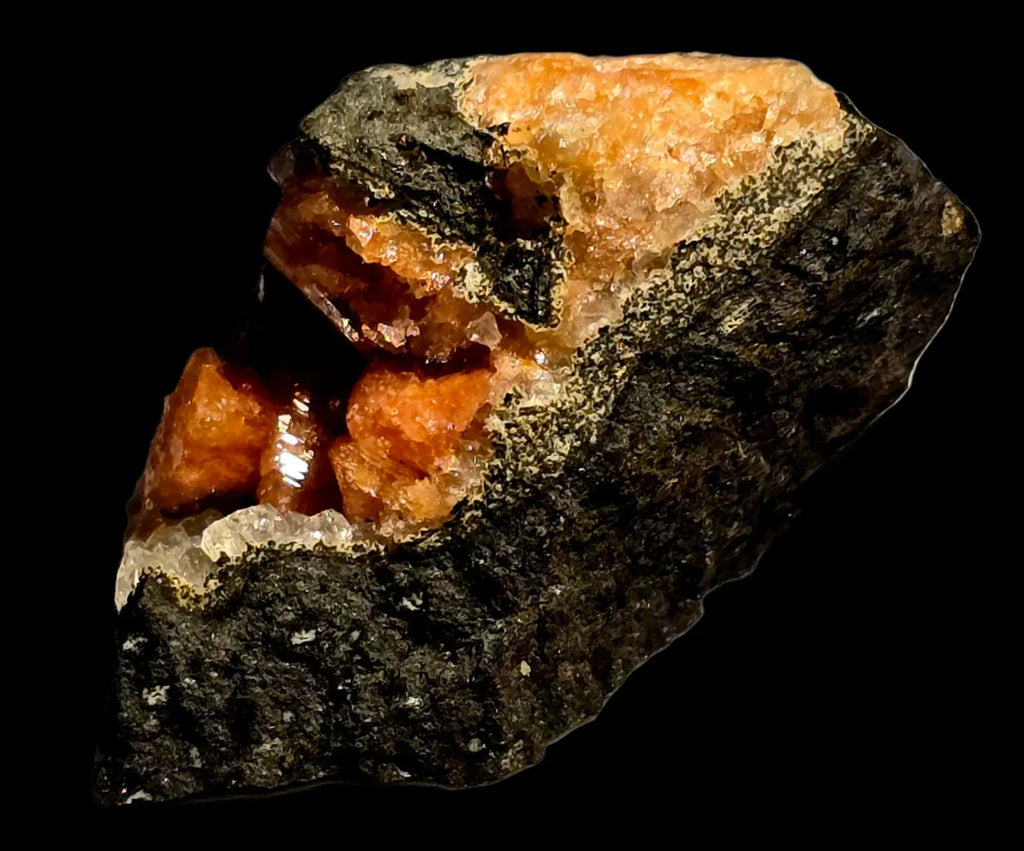 Orange spessartine garnet crystals on dark matrix, mineral specimen