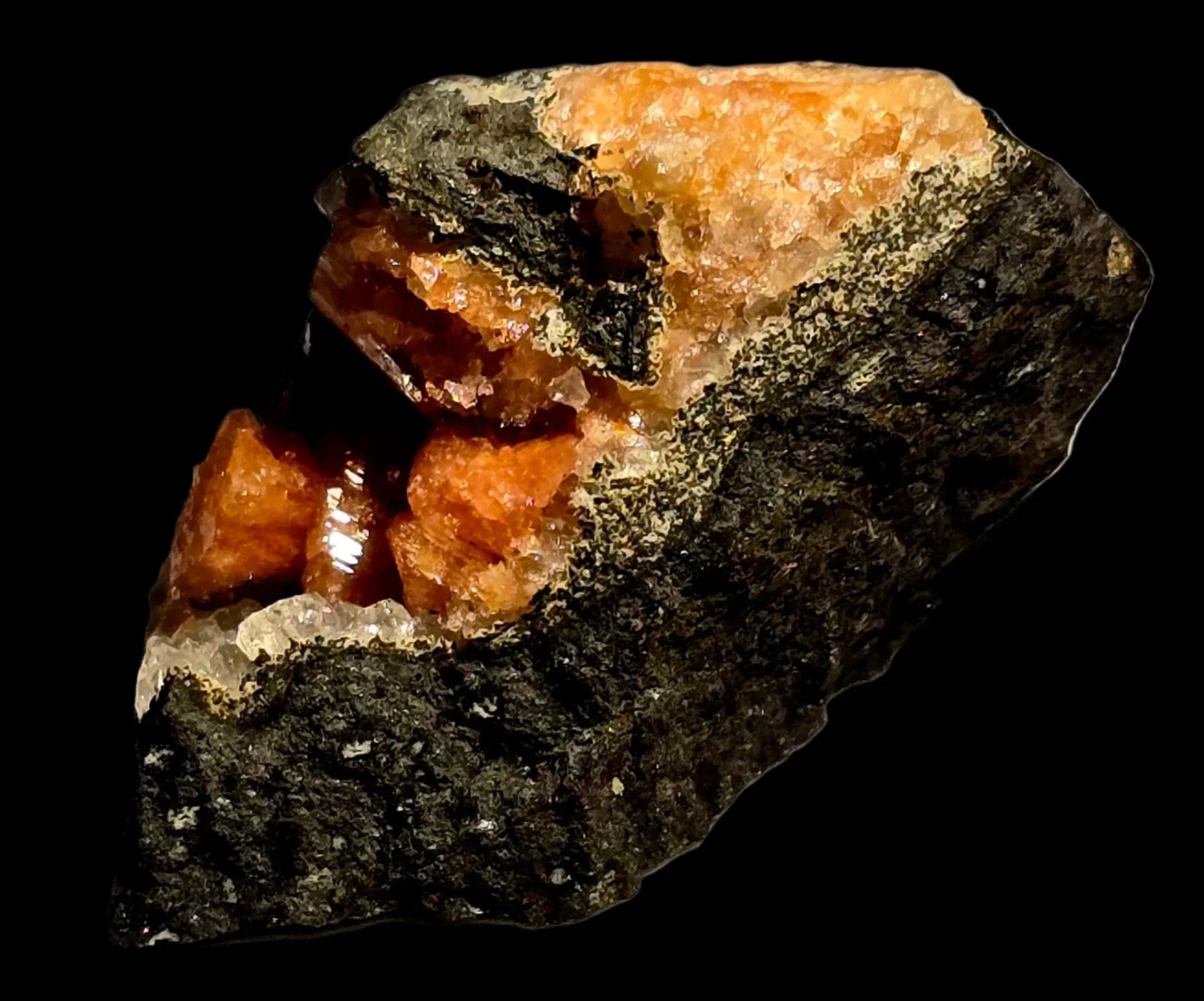 Orange spessartine garnet crystals on dark matrix, mineral specimen