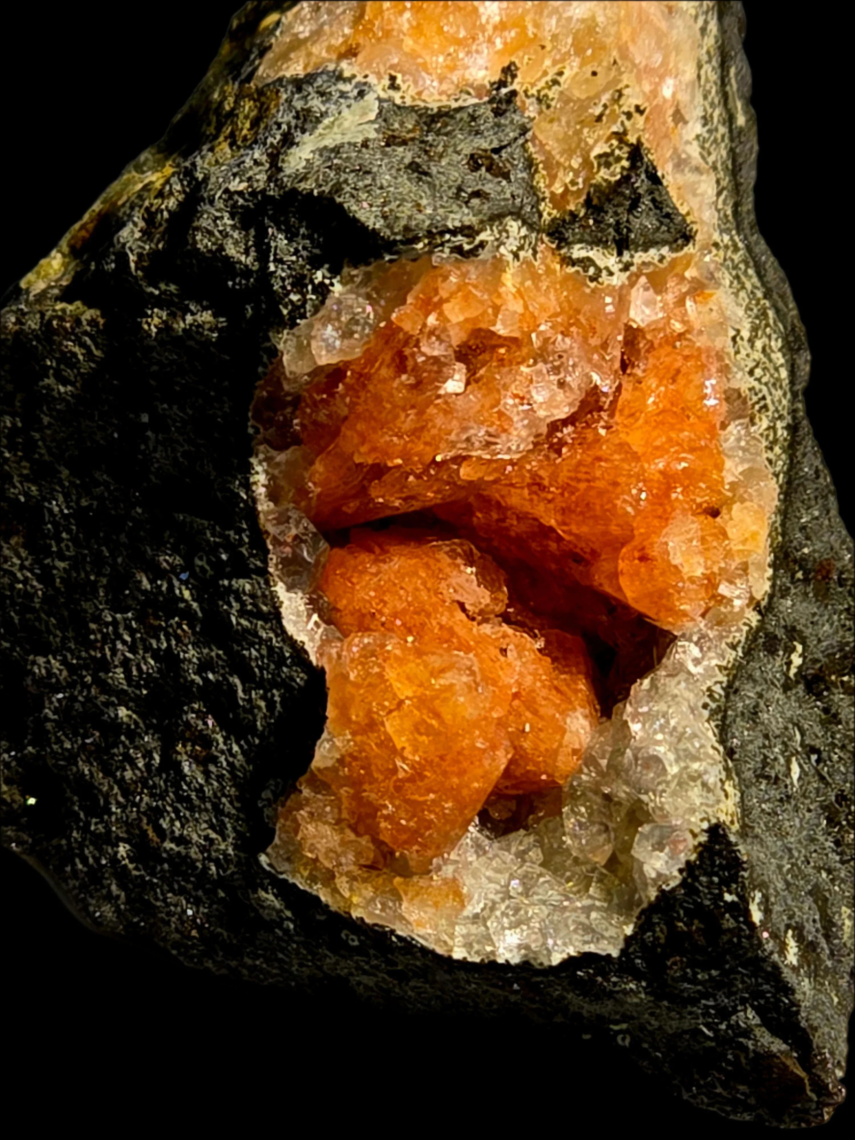 Vibrant orange crystal cluster in dark matrix, mineral specimen for collectors