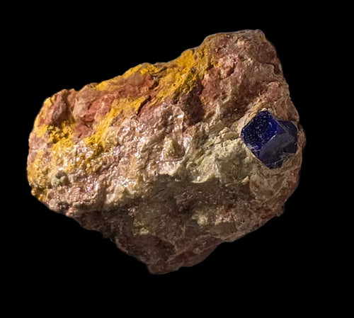 Sapphire crystal in matrix from Australia, vibrant blue gemstone with yellow and brown host rock