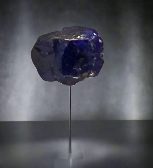 Tanzanite crystal specimen from Tanzania on display stand, deep blue violet mineral for collectors
