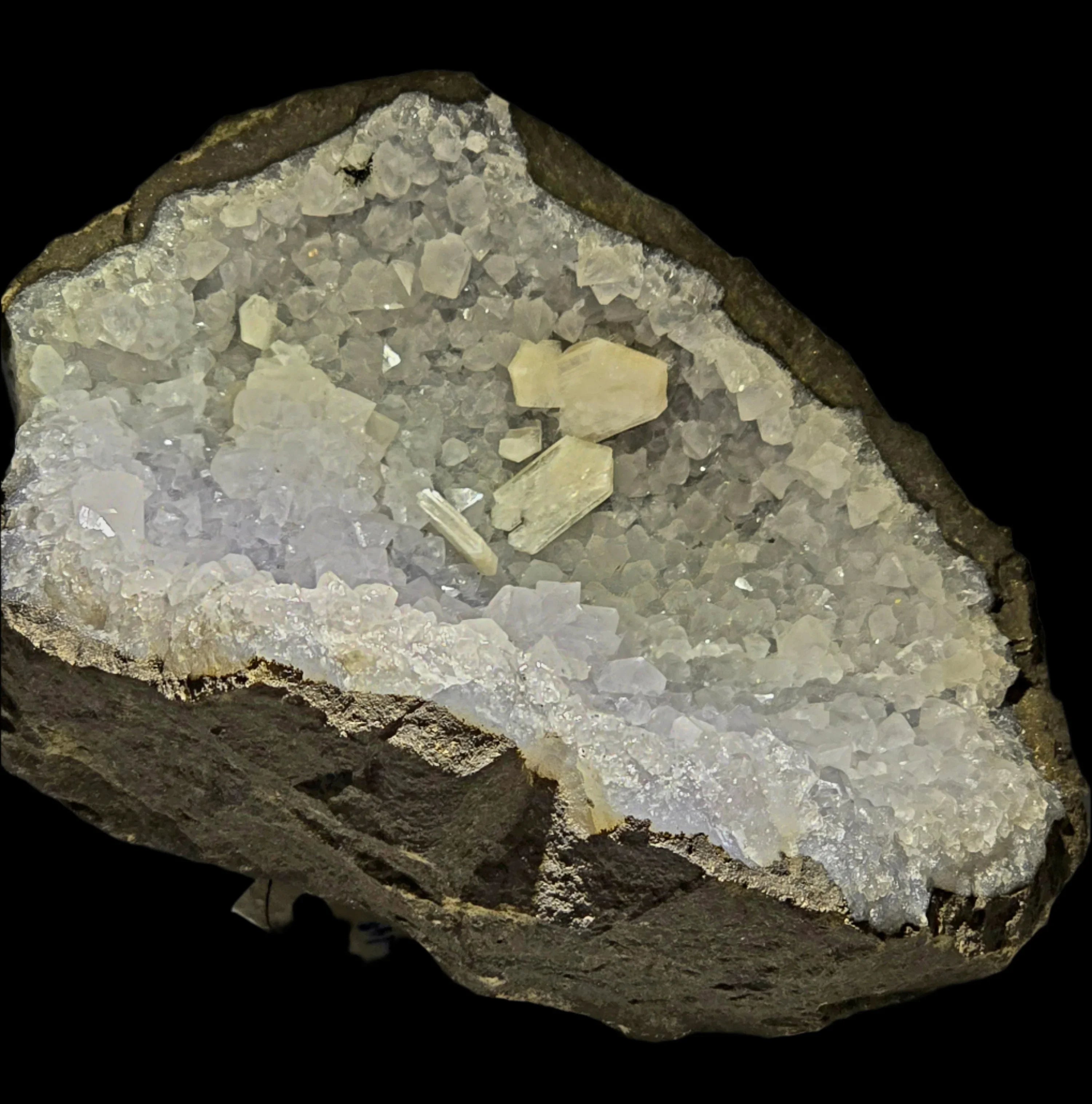 Celestine crystal cluster with matrix, showcasing clear to pale yellow cubic crystals on dark rock base