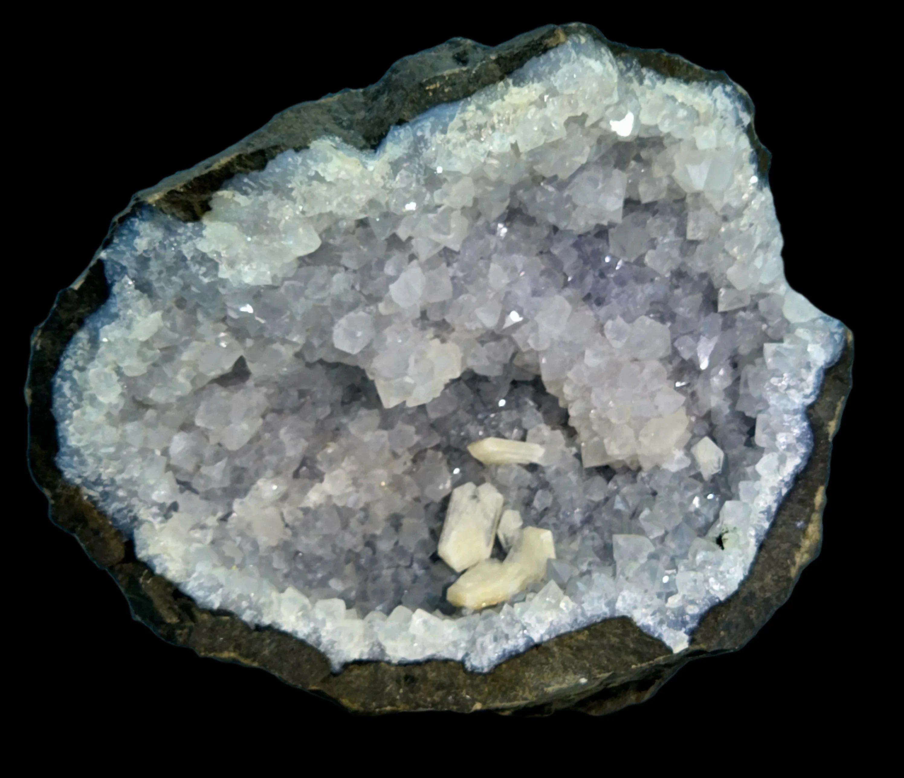 Celestine crystal cluster from Madagascar, showcasing white to pale blue cubic crystals in a geode matrix