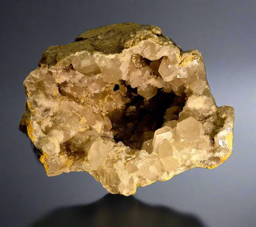 Heulandite crystal specimen from India, showcasing translucent golden crystals in a geode cavity