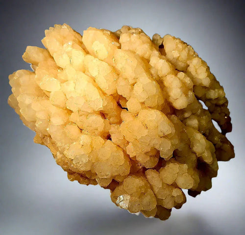 Calcite crystal cluster from Elmwood Mine, Tennessee, showcasing golden-yellow, botryoidal formations with sparkling facets.