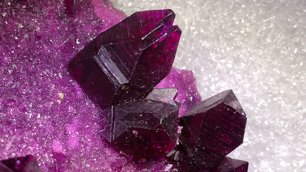 Deep purple fluorite crystals with sharp facets and glittering matrix, ideal for mineral collectors