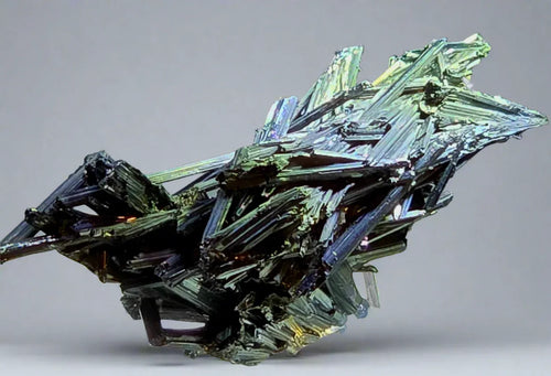 Bismuth crystal with iridescent rainbow hues, geometric stepped growth, metallic luster, mineral specimen