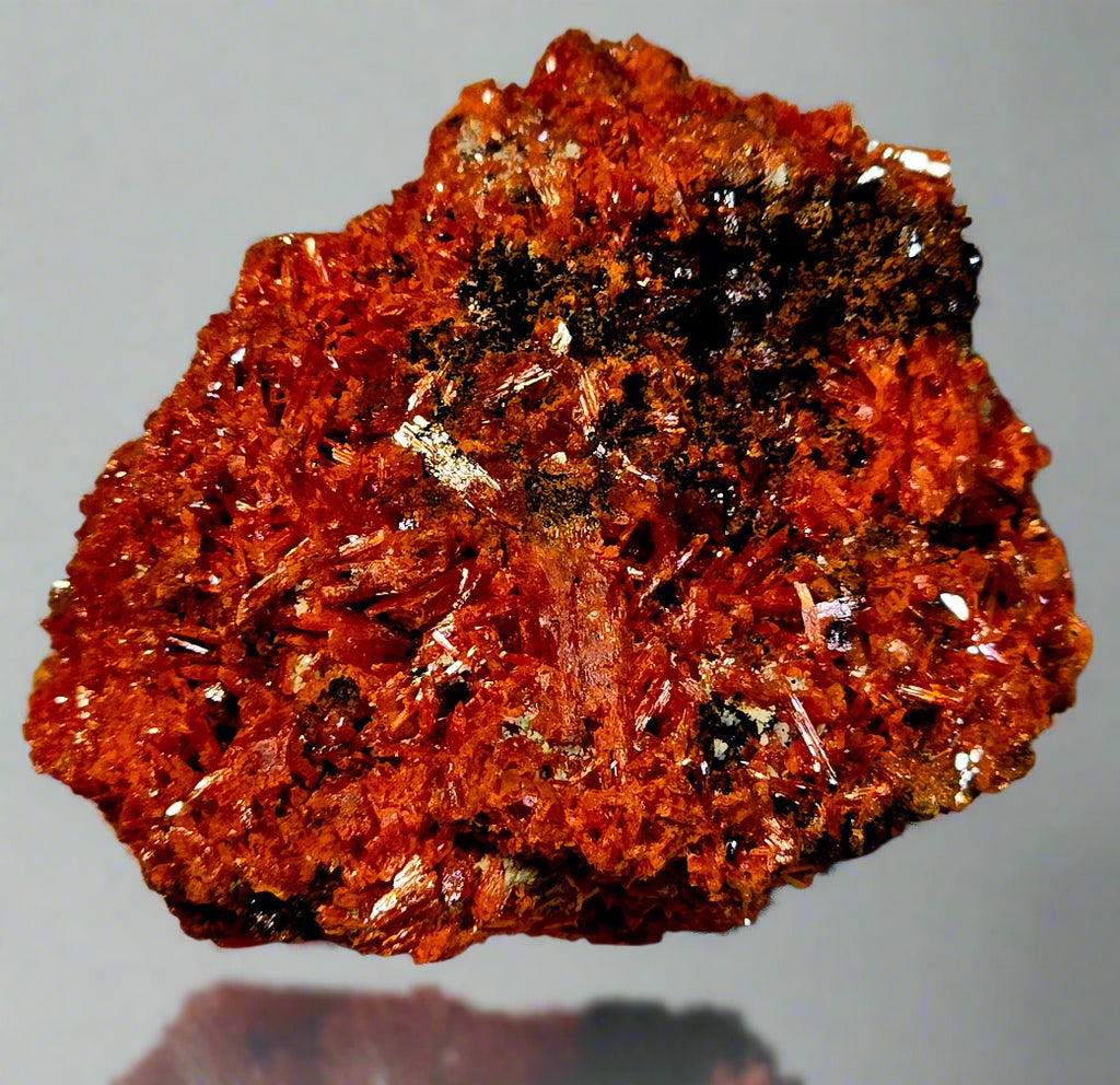 Close-up of a red-brown mineral specimen on a textured surface