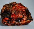 Mineral sample with red and black colors on a beige background