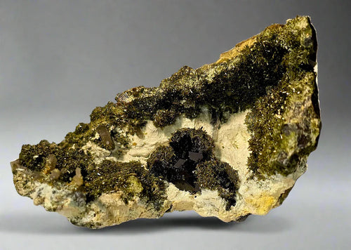 Pyrite on matrix from Huanzala Mine, Peru - mineral specimen with metallic crystals and green oxidation