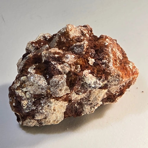 Hematite mineral specimen with earthy brown and metallic gray textures, natural crystal formation