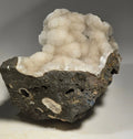 Quartz crystal cluster on dark volcanic rock, sparkling mineral specimen for collectors