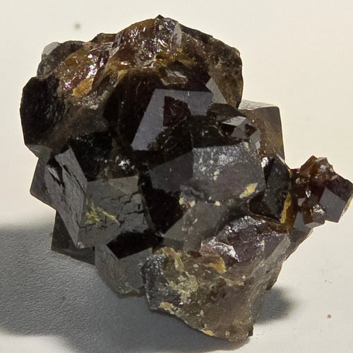 Fluorite cube crystal specimen with metallic luster, showcasing geometric mineral formation and earthy matrix.