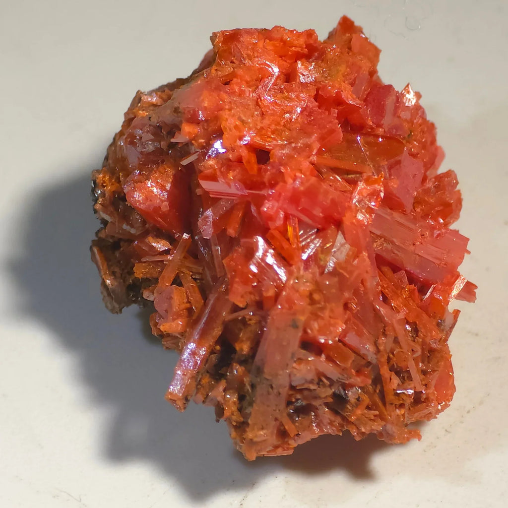 Crocoid mineral specimen with vibrant red-orange crystals, showcasing sharp prismatic formations on matrix.