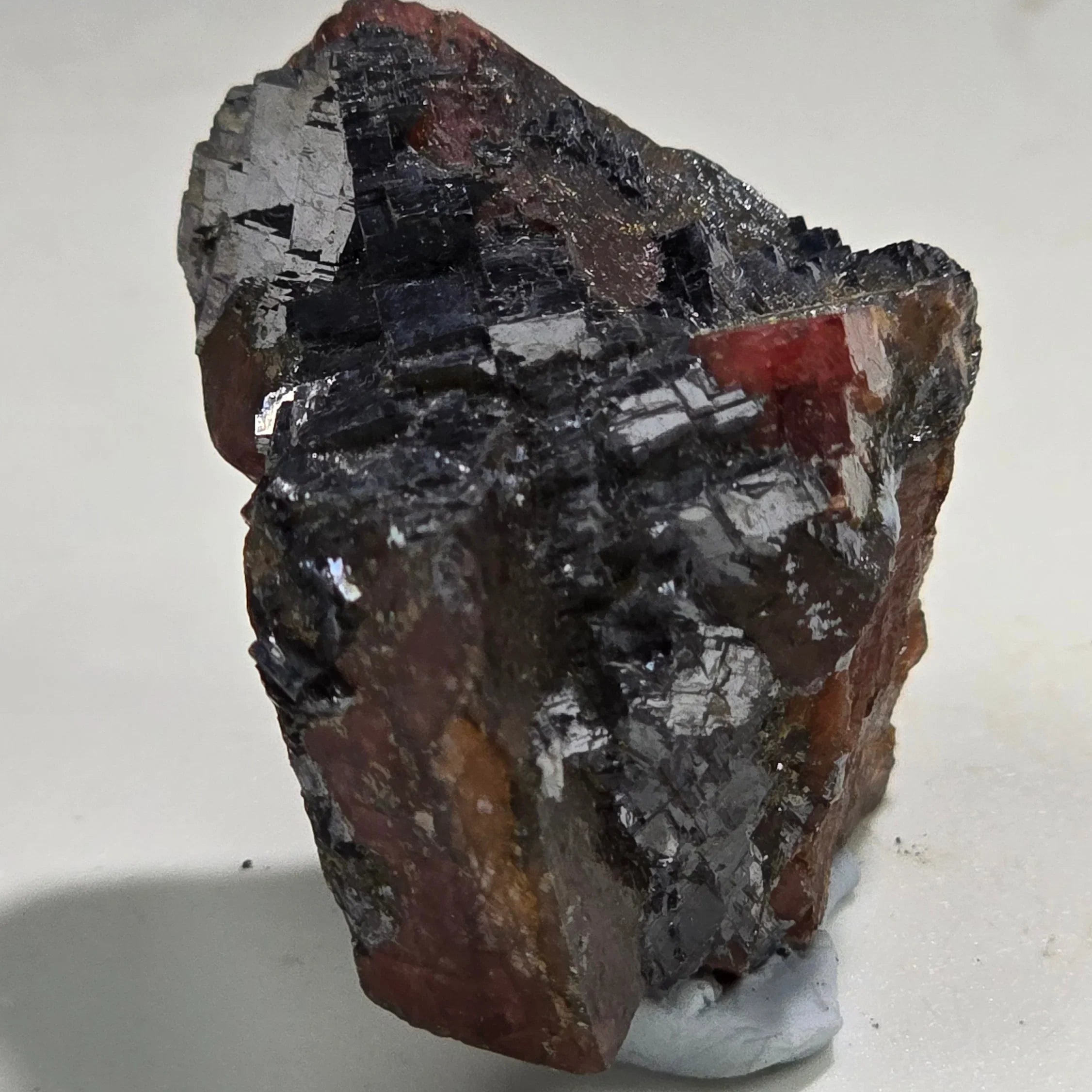 Hematite with red matrix, showcasing metallic luster and crystalline texture, ideal for mineral collectors.