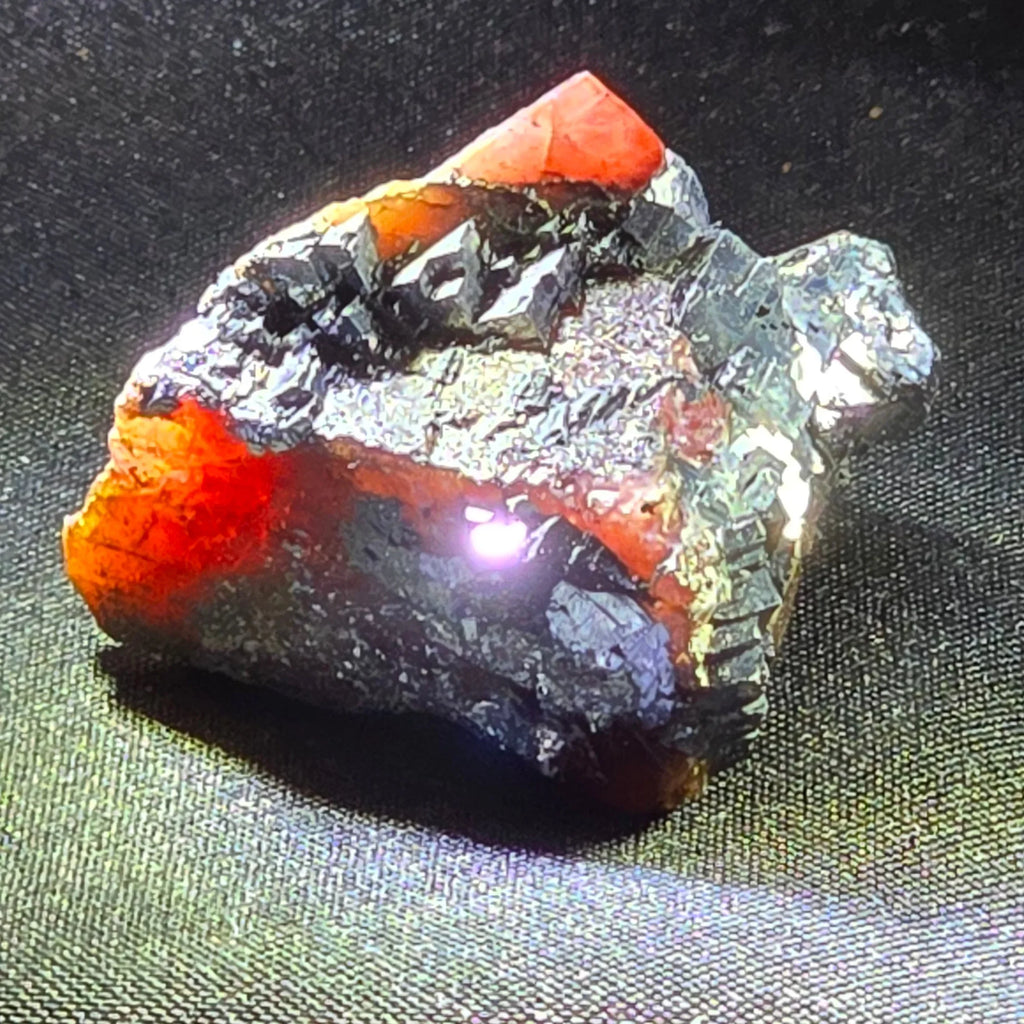 Vibrant orange-red mineral specimen with metallic crystals on dark matrix, ideal for collectors