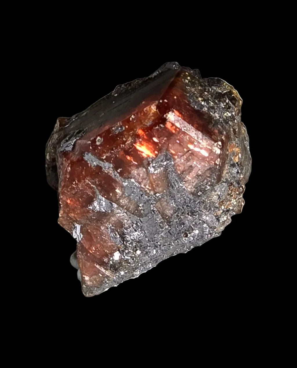 Spessartine Garnet crystal from Namibia, showcasing deep red-orange facets and metallic inclusions against black background