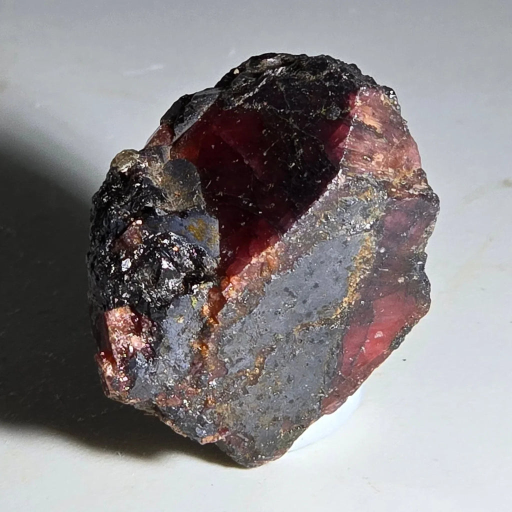 Almandine Garnet crystal with deep red interior and dark matrix, natural mineral specimen