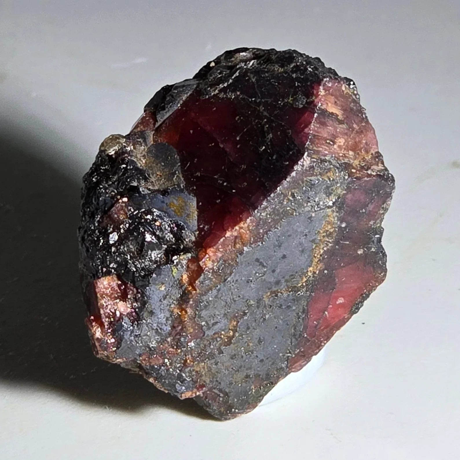 Almandine Garnet crystal with deep red interior and dark matrix, natural mineral specimen