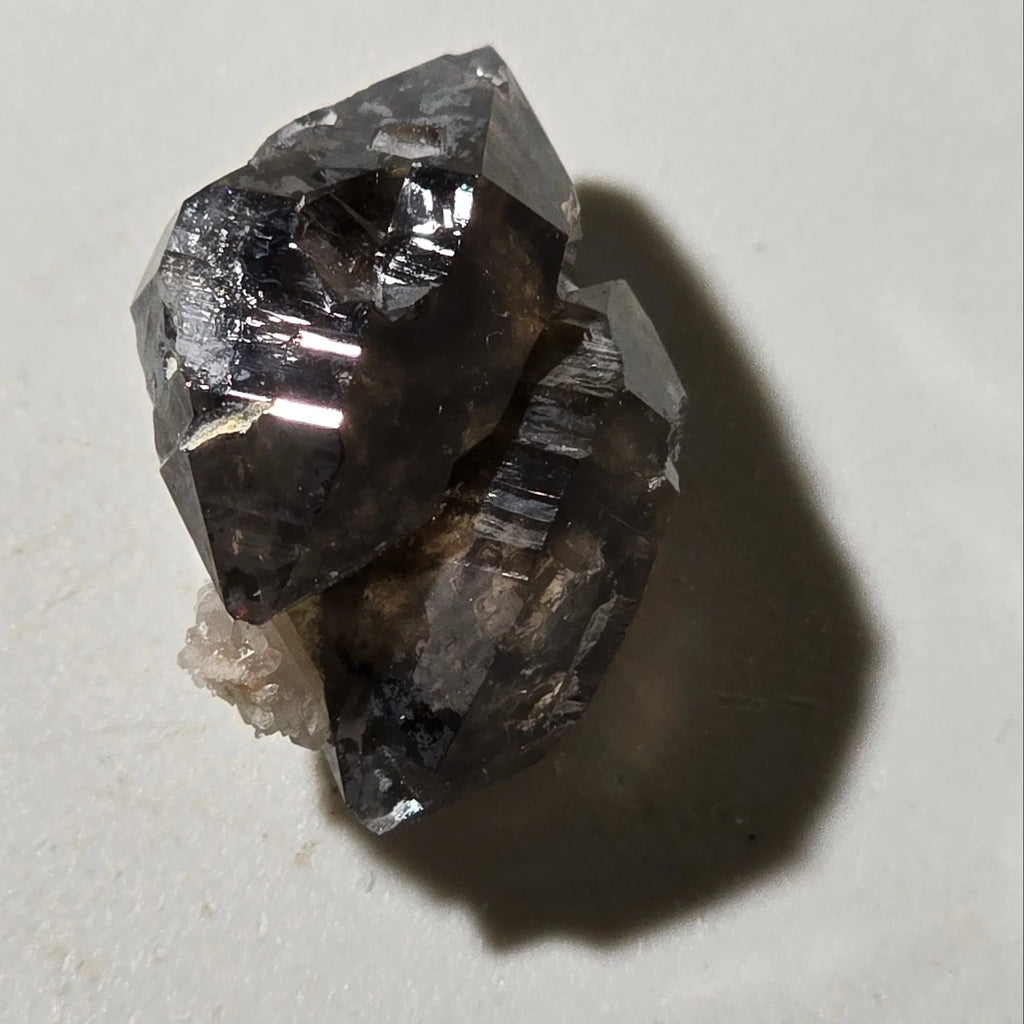 Hematite crystal specimen with metallic luster and striations, showcasing natural mineral formation