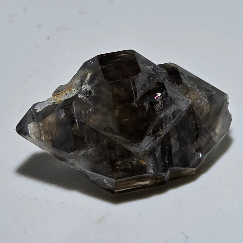 Fluorite crystal specimen with cubic geometry, dark translucent facets, and minor matrix from classic locality
