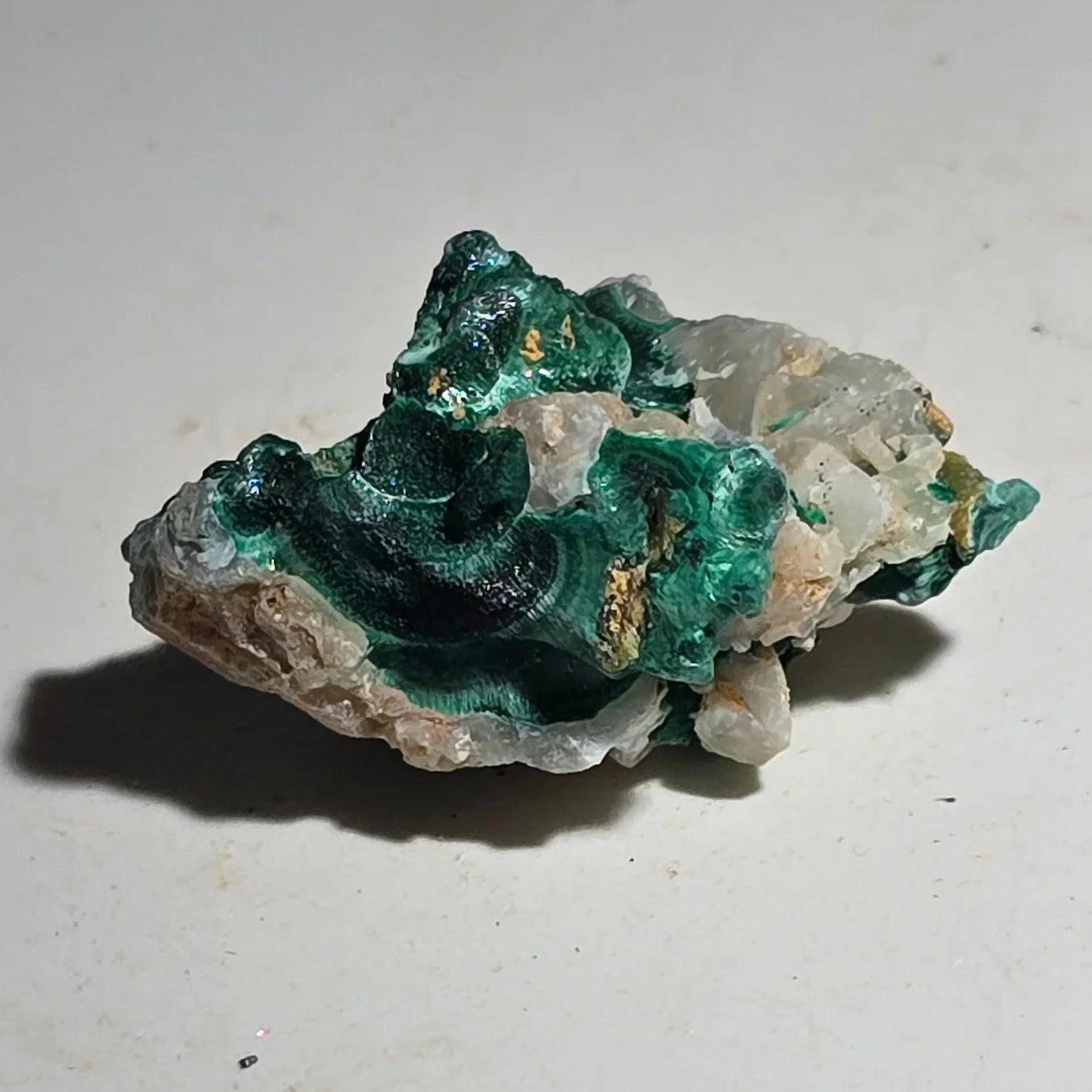 Malachite on Quartz specimen, vibrant green mineral with banded patterns, natural crystal formation