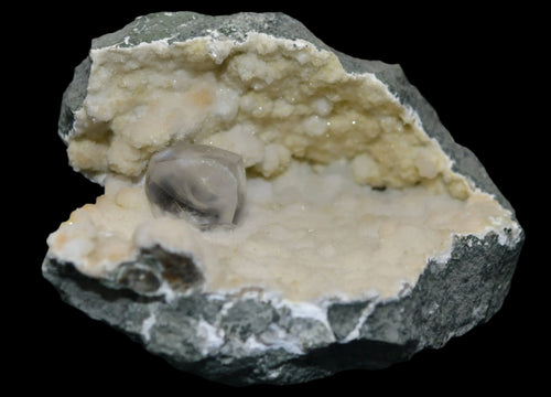 Fluorite crystal in matrix, showcasing natural mineral specimen with cubic formation and earthy tones