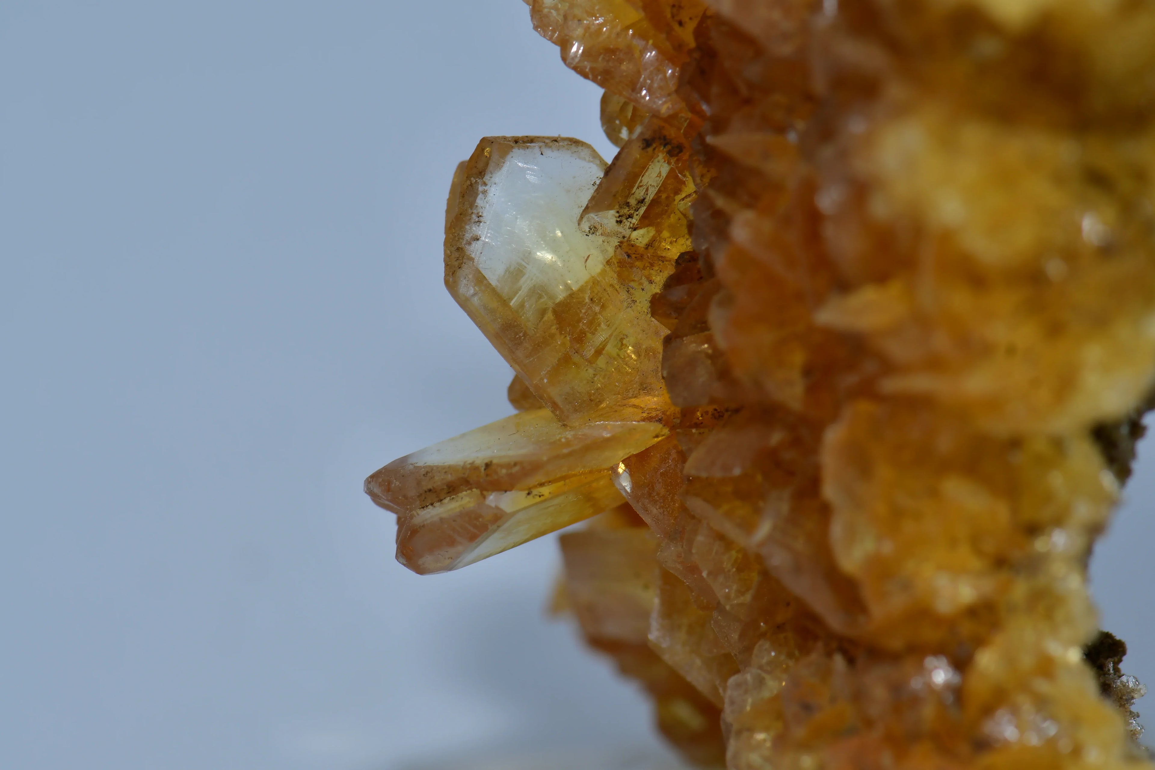Topaz crystal specimen with golden hue, showcasing natural mineral formation and clarity against light background