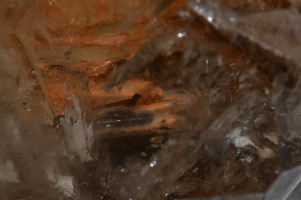 Clear quartz crystal with iron oxide inclusions, showcasing natural mineral formations