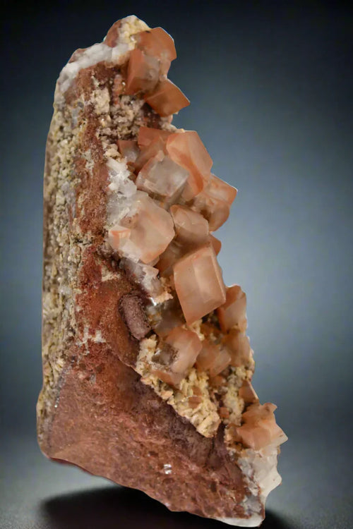 Aragonite crystals from Spain, showcasing translucent orange cubes on a matrix, ideal for mineral collectors.